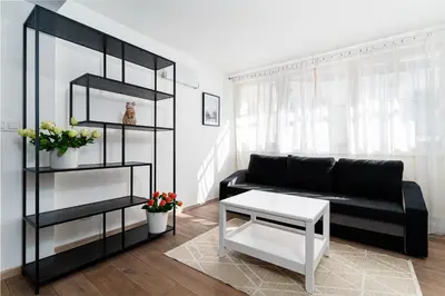 a living room with a black couch and a table at Deluxe Rabbit Suite in Prague