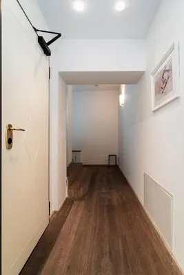 an empty hallway with a door and wood floors at Deluxe Rabbit Suite in Prague