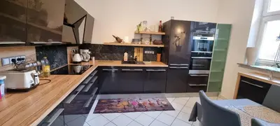 a kitchen with black cabinets and a counter top at Sweet home apartment Kobylisy in Prague
