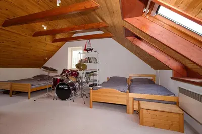 a attic bedroom with two beds and a room with wooden ceilings at Chalupa Všetice in Netvořice