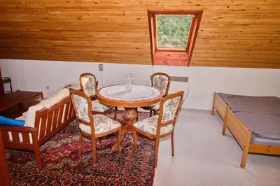 a room with a table and chairs and a bed at Chalupa Všetice in Netvořice