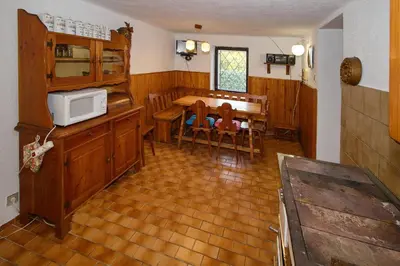 a kitchen and dining room with a table and a microwave at Chalupa Všetice in Netvořice