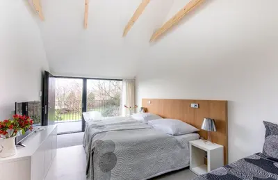 a white bedroom with a bed and a window at Yard Resort in Předboj