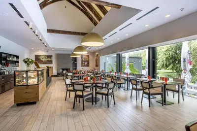 a restaurant with tables and chairs and large windows at Yard Resort in Předboj