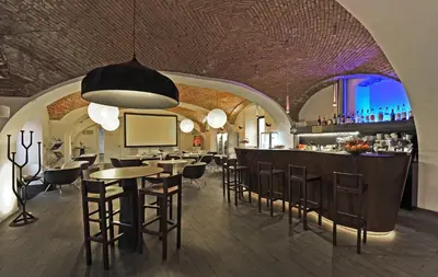 a restaurant with a bar with tables and chairs at Yard Resort in Předboj