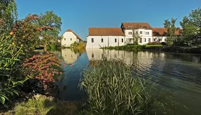 a view of a river with houses and buildings at Yard Resort in Předboj