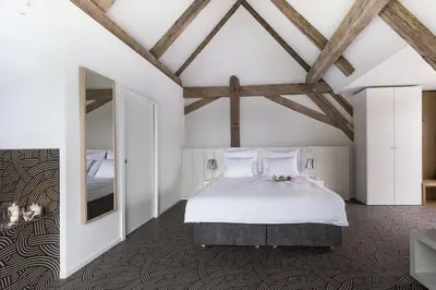 a bedroom with a bed and a large window at Yard Resort in Předboj