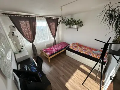 a small room with two beds and a window at Private rooms, stunning city views, top-floor with balcony, bathtub, Internet, coffee in Prague