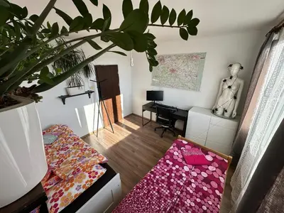 a living room with a couch and a table at Private rooms, stunning city views, top-floor with balcony, bathtub, Internet, coffee in Prague