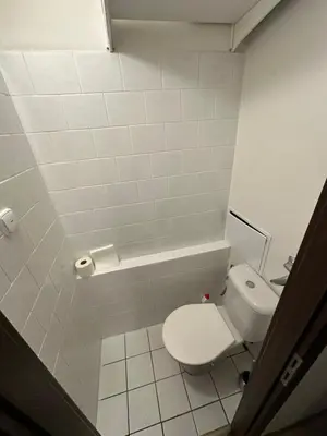 a white bathroom with a toilet and a sink at Private rooms, stunning city views, top-floor with balcony, bathtub, Internet, coffee in Prague
