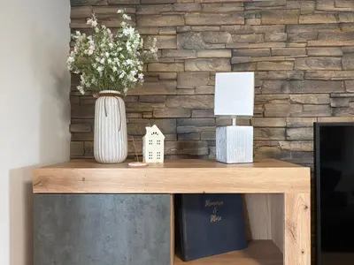 a wooden table with a vase of flowers on it at Home by the Pool & Garden in Srbín