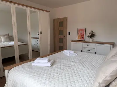 a bedroom with a white bed with towels on it at Home by the Pool & Garden in Srbín