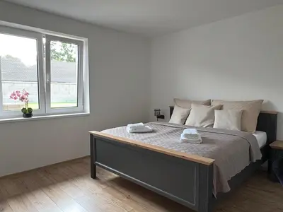 a bedroom with a large bed with two towels on it at Home by the Pool & Garden in Srbín