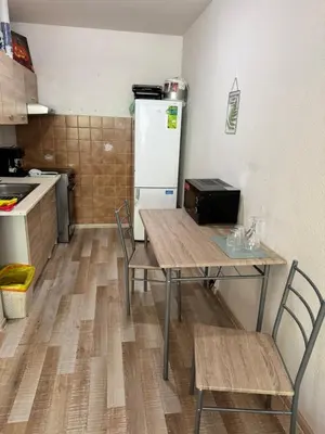 a kitchen with a table with two chairs and a refrigerator at Lužiny in Prague