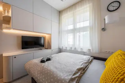 a bedroom with a bed with a clock and a tv at Urban Hideaway in Prague