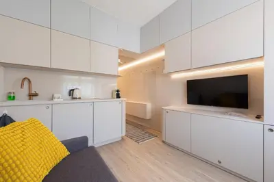 a living room with white cabinets and a tv at Urban Hideaway in Prague