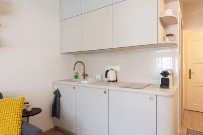 a kitchen with white cabinets and a sink at Urban Hideaway in Prague