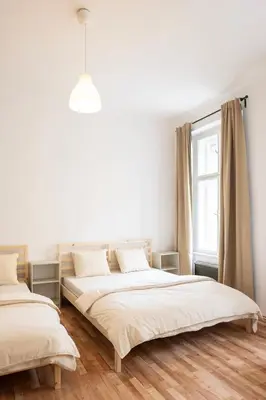 two beds in a white room with a window at Masaryk Lounge in Prague