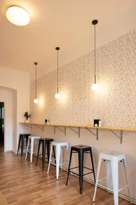 a row of stools in a restaurant with lights at Masaryk Lounge in Prague