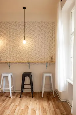 two tables and two stools in a room with a wall at Masaryk Lounge in Prague