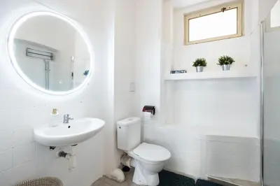 a white bathroom with a toilet and a sink at Masaryk Lounge in Prague