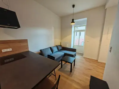 a living room with a blue couch and a table at Modern 1BR in trendy Žižkov in Prague