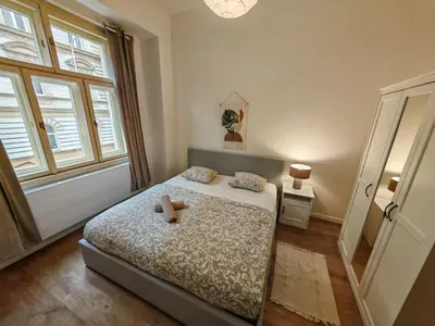 a bedroom with a bed with a teddy bear on it at Modern 1BR in trendy Žižkov in Prague