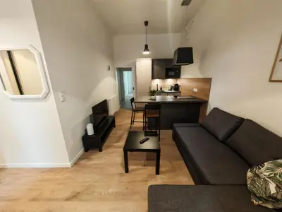 a living room with a couch and a kitchen at Modern 1BR in trendy Žižkov in Prague