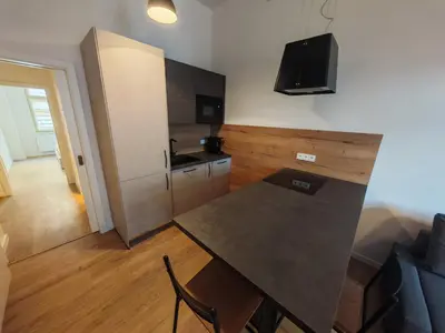 a small kitchen with a table and a couch at Modern 1BR in trendy Žižkov in Prague