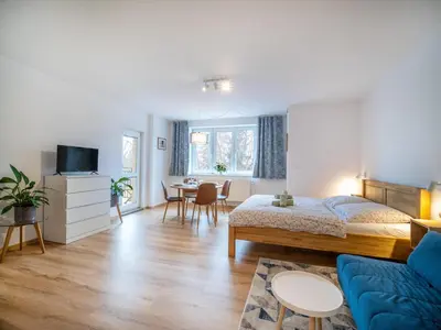 a bedroom with a bed and a living room at Apartmán Ve středu dění in Poděbrady