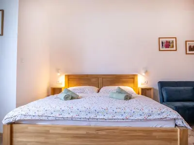 a bedroom with a bed and a blue chair at Apartmán Ve středu dění in Poděbrady