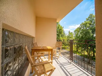 a balcony with a wooden table and chairs at Apartmán Ve středu dění in Poděbrady