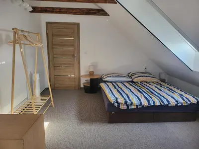 a bedroom with a bed with a ladder and a window at Ubytování U100bodů za švestkovou dráhou