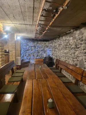 a long wooden table in a room with stone walls at Ubytování U100bodů za švestkovou dráhou