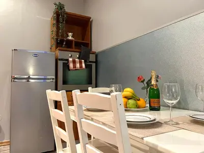 a kitchen with a table with chairs and a refrigerator at The Dragonfly Residence in Prague