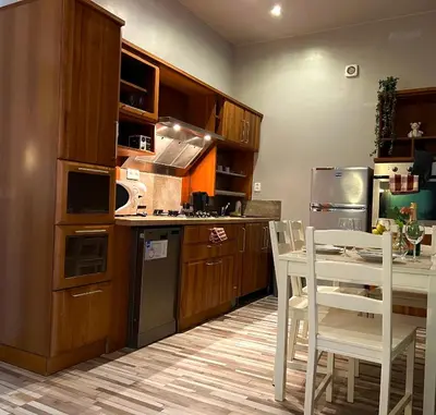 a kitchen with wooden cabinets and a table and chairs at The Dragonfly Residence in Prague