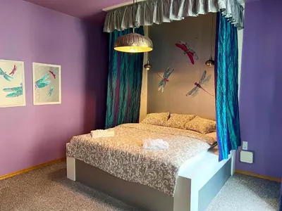a bedroom with a bed with purple walls at The Dragonfly Residence in Prague
