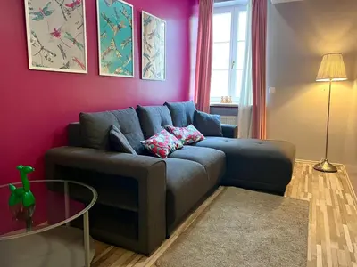a living room with a blue couch and a pink wall at The Dragonfly Residence in Prague