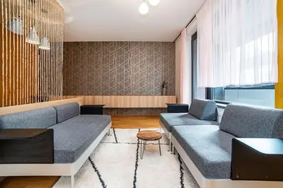 a living room with two couches and a table at Spacious studio with free parking in Prague