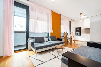a living room with a couch and a table at Spacious studio with free parking in Prague