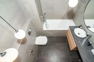 a bathroom with two sinks and a tub and a toilet at Spacious studio with free parking in Prague