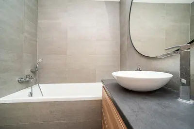 a bathroom with a sink and a tub and a mirror at Spacious studio with free parking in Prague