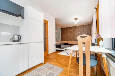a kitchen and dining room with a table in a room at Spacious studio with free parking in Prague