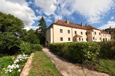 an old building with a pathway in front of it at Suite at Château Domoušice in Domoušíce