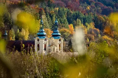 an old building with two towers in the middle of a forest at Suite at Château Domoušice in Domoušíce