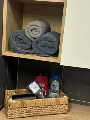 a basket with towels and other items in a bathroom at Kubánské náměstí in Prague