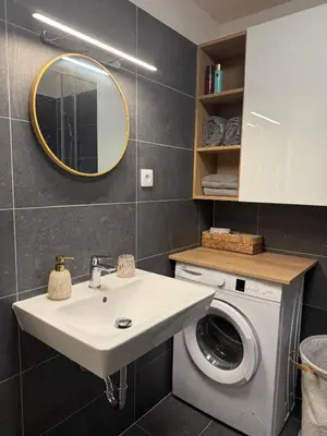 a bathroom with a sink and a washing machine at Kubánské náměstí in Prague