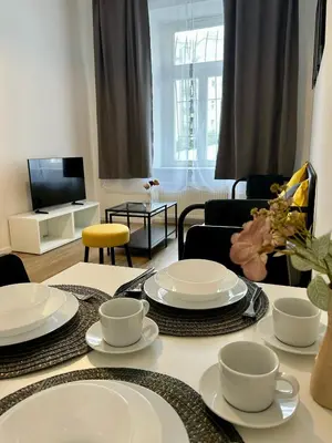 a living room with a table with white dishes on it at Centre Apartment by the River in Prague