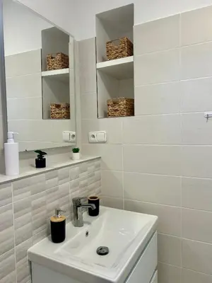 a white bathroom with a sink and a mirror at Centre Apartment by the River in Prague