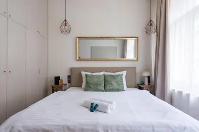 a bedroom with a large white bed with a mirror at Zen Garden in Prague